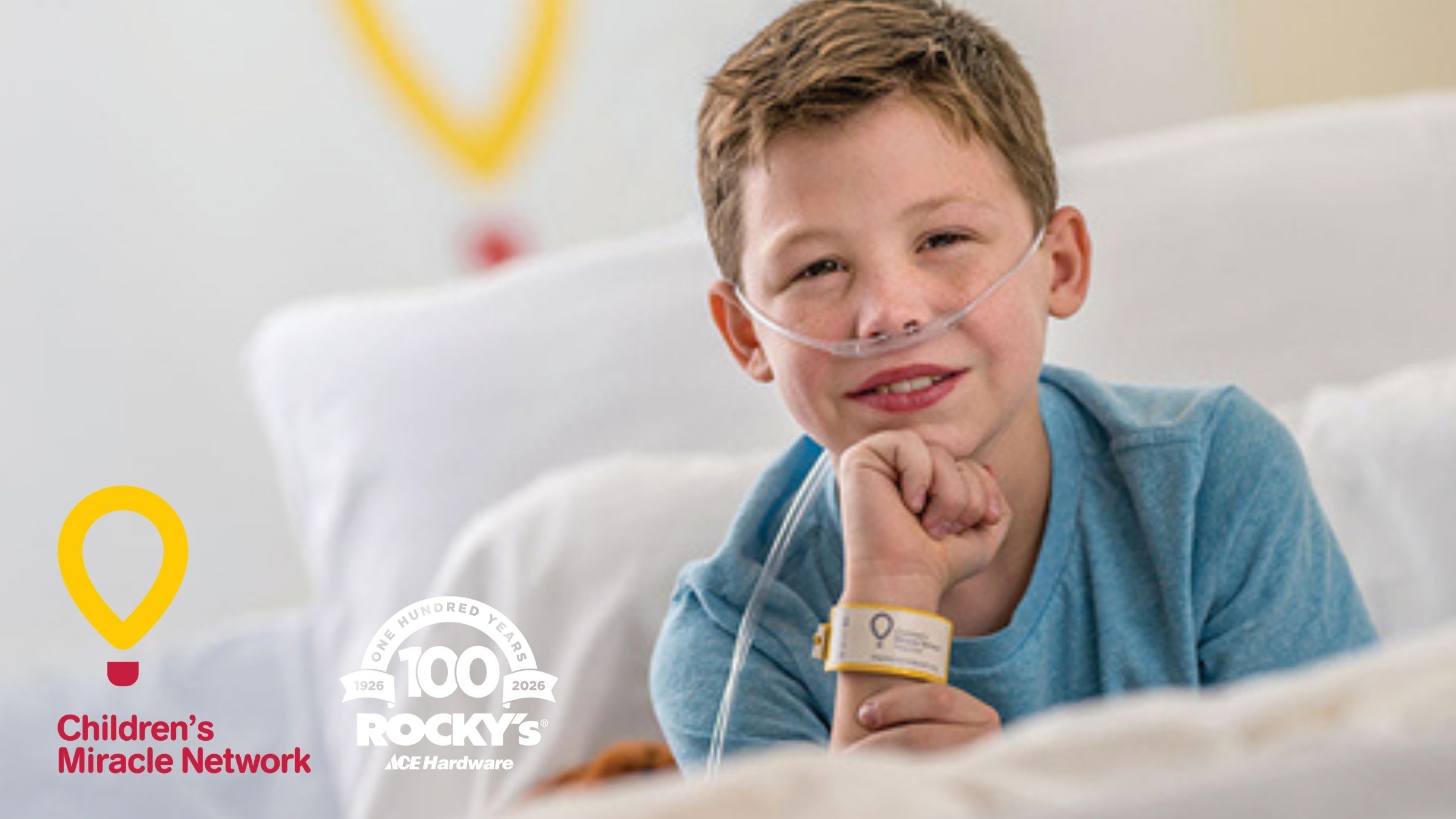 RockysBucketDaysCMNBlogPost2026 A child in a hospital bed, smiling, the Children's Miracle Network Logo visible in the background.